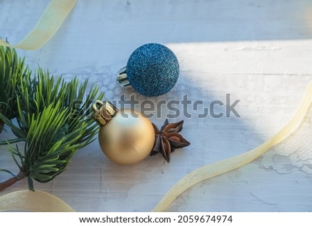 winter holidays decor background with golden ribbon christmas balls and star anise on white wooden background