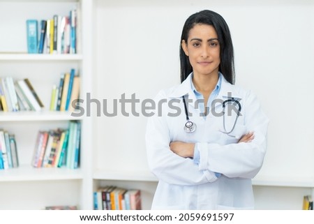 Serious mexican female doctor with copy space at clinic