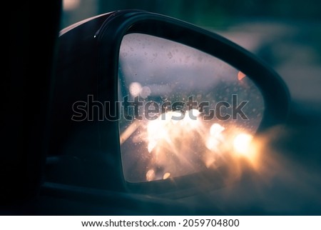 Car lights reflected in the rear view mirror Royalty-Free Stock Photo #2059704800
