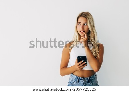 Close up photo of scared disappointed lady holding telephone in hand looking at screen isolated grey background