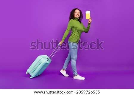 Photo of dreamy excited african lady dressed green turtleneck smiling holding passport baggage isolated violet color background