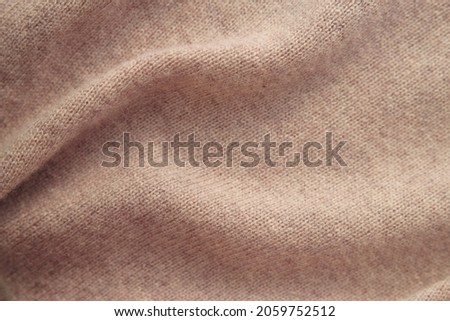Close up of cashmere fabric with folds. Warm knitted natural background. Royalty-Free Stock Photo #2059752512