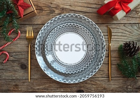 Creative Christmas table setting. Empty plates on rustic wooden xmas background. Royalty-Free Stock Photo #2059756193