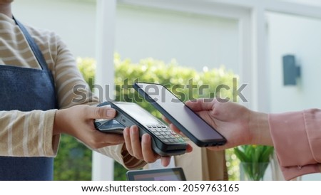 Close-up hand asia woman people work in small sme coffee cafe shop store owner use cashless wifi paywave nfc scan app smart pos reader sale in take out food drink order in urban city life contactless. Royalty-Free Stock Photo #2059763165