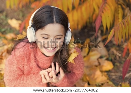 Feel joy. Kid girl relaxing near autumn tree with headphones. Music for autumn cozy mood. Autumn playlist concept. Enjoy music outdoors fall warm day. Listening song. Audio file. Educational podcast