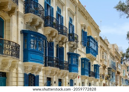 Residential house facade with traditional Maltese navy blue enclosed wooden balconies in Valletta, Malta, in summer day. Authentic Maltese urban scene. Royalty-Free Stock Photo #2059772828