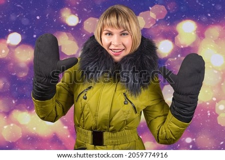 portrait of smiling young woman in winter jacket with fur collar on blurred colored background