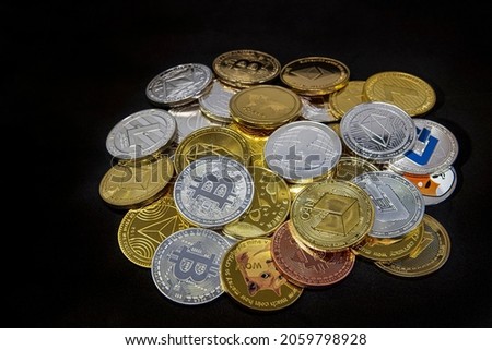 Horizontal view of cryptocurrency tokens, including Bitcoin, Ethererum Ripple, and Litecoin saw from above on a yellow gold background. High quality photo