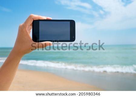 photoshooting on smartphone at sea coast