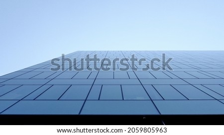 Tall City Skyscraper Corporate Building Windows Against Blue Sunny Sky in Summer