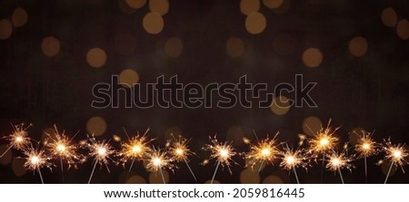 Holiday New Year's Eve Silvester New Year Party Birthday Wedding festive background banner greeting card	- Many burning sparkler in the dark black night with bokeh golden light Royalty-Free Stock Photo #2059816445