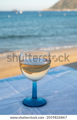 Summer time in Provence, drinking of cold dry gris rose wine on sandy beach and blue sea near Toulon, Var department, France