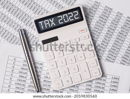 Tax 2022, taxation system. Word on calculator on documents.