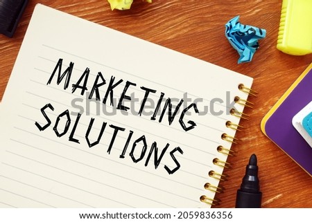 Financial concept about MARKETING SOLUTIONS question marks with inscription on the sheet. 
