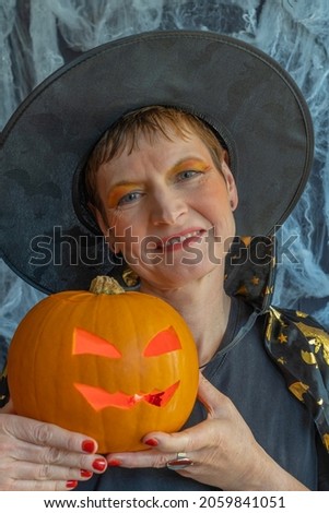 Gennevilliers, France - 10 16 2021: A witch preparing a pumpkin for Halloween