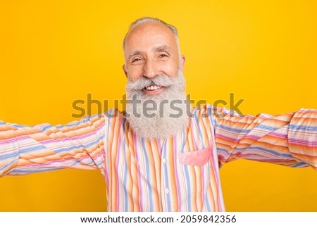 Self-portrait of attractive cheerful content grey-haired man good mood isolated over bright yellow color background