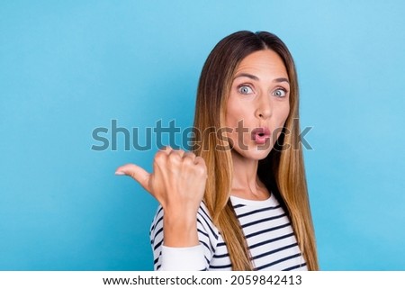 Profile photo of young blond impressed lady point empty space wear striped shirt isolated on blue color background