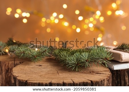 Christmas background with natural wood scene and defocus lights. Rustic composition with fir branches, gifts, mockup for products and goods.