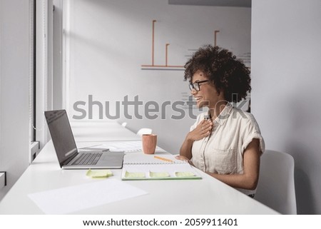Afro American woman learning and communicating in sign language online while sitting near window