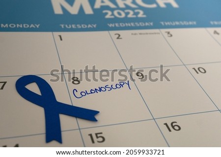 Calendar reminder for colonoscopy appointment in March, which is Colon Cancer Awareness month. The blue ribbon represents the month. Royalty-Free Stock Photo #2059933721
