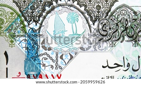 1 Riyal banknote, Bank of Qatar, closeup bill fragment shows Coat of arms depicting sailboats, palm trees and crossed swords, issued 2008
