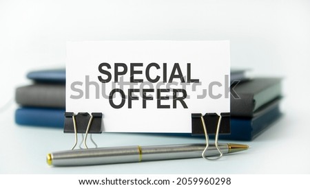 a white notebook with the text SPECIAL OFFER lies on a white paper card, business cconncept