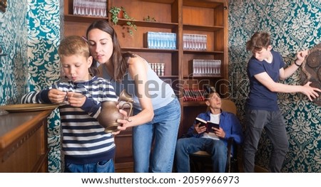 Friendly family with children is trying to find a solution to the puzzle in the confined space of a lost room Royalty-Free Stock Photo #2059966973