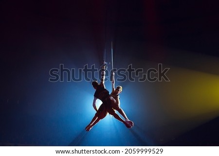 Circus actress acrobat performance. Two boys perform acrobatic elements in the air Royalty-Free Stock Photo #2059999529