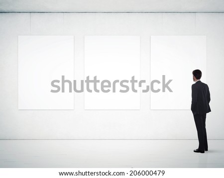 Businessman in gallery room looking at empty frames