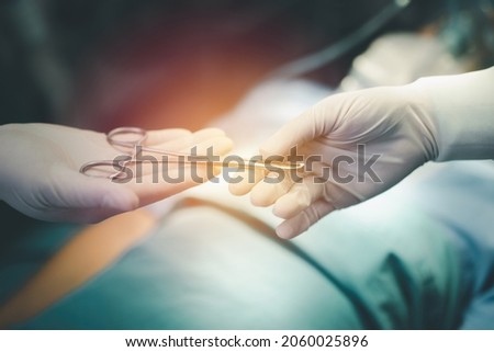 Close-up of the hands of the surgeon's team who picked up the telescope and delivered them to each other in the operating room. Royalty-Free Stock Photo #2060025896
