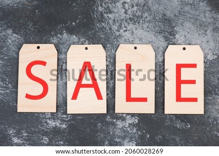 Tags with the word sales in red color, dark textured background, empty copy space