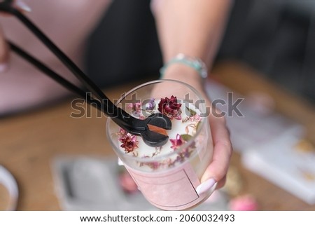 Cutting the wick out of handmade soy candles. Candle making utensils. Cruelty-free vegan product Royalty-Free Stock Photo #2060032493
