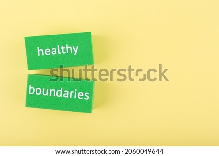 Minimal simple flat lay with green rectangle with written healthy boundaries text on bright yellow background with copy space. Mental health day, psycology, mental health assessment and awareness Royalty-Free Stock Photo #2060049644