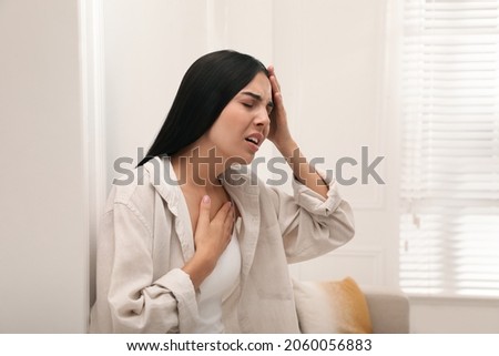 Young woman suffering from breathing problem at home Royalty-Free Stock Photo #2060056883