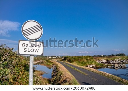 Sign asking for driving slow in irish : Go Mall