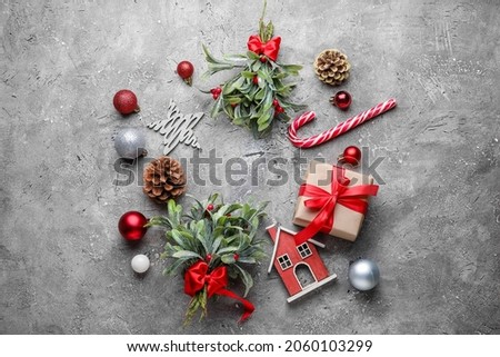 Frame made of mistletoe branches and Christmas decor on grunge background