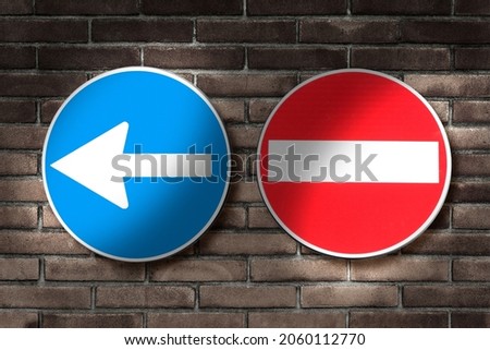 Directional arrow road sign and no entry road sign against a brick wall - concept image