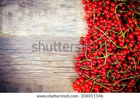 red currants on a dark wood background. toning. selective focus on middle left currants