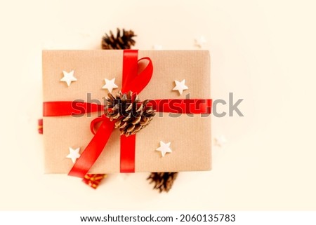 Christmas gift box with red bow on beige background. Holiday concept, New year presents.