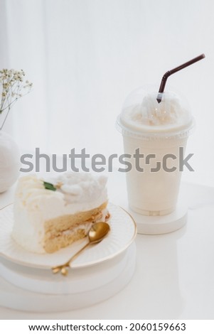 Double Rich creamy white cake and Rich premium sliced coconut butter mousse cake on the white plate with iced milk in the white background