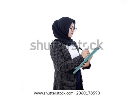 Portrait of an Asian businesswoman writing in a folder isolated on white background