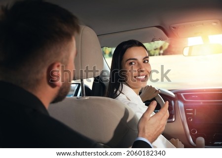 Young man talking with driver in modern car