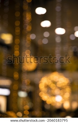 festive lights from garland lamps inside shopping mall yellow unfocused illumination, vertical abstract photography 