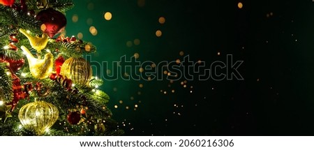 Decorated with ornaments and lights Christmas tree on dark green background. Merry Christmas and Happy Holidays greeting card, frame, banner. New Year. Noel. Winter holiday theme. 
