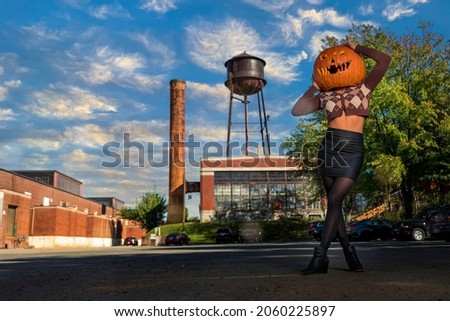 A beautiful model poses with a pumpkin on her head for the halloween season in the United States