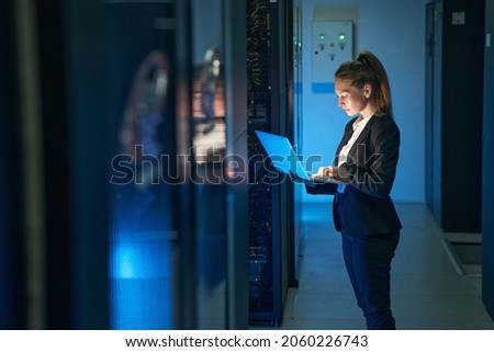 Female engineer working in server room at modern data center Royalty-Free Stock Photo #2060226743