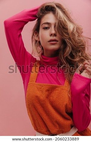 Close-up studio shot beautiful young russian woman with gorgeous facial features standing against pink background. Look is mesmerizing, natural makeup, blonde hair, soft lips of blonde beauty.