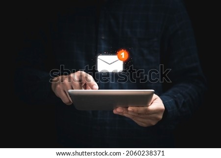 Businessman holding tablet and touching with virtual white newsletter for electronic mail or E-mail with notification alert concept. Royalty-Free Stock Photo #2060238371