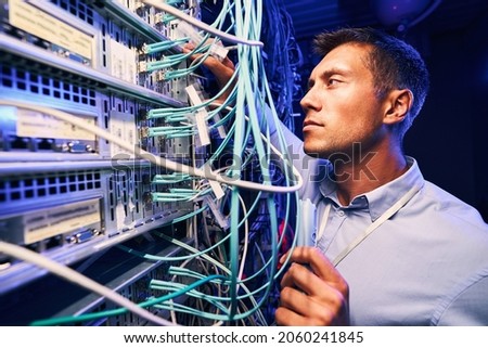 Technician monitoring fiber optic cables with electronic device Royalty-Free Stock Photo #2060241845