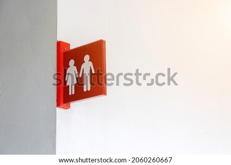 Red toilet sign on white wall